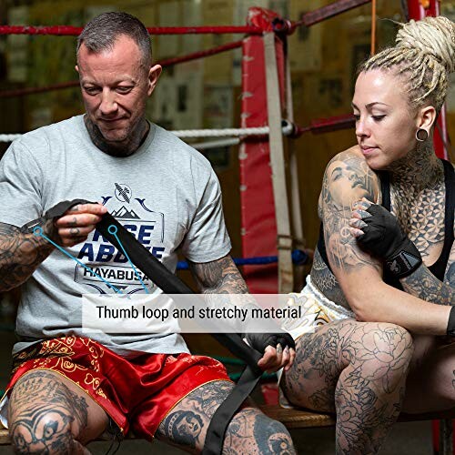 Two people preparing for boxing with hand wraps in a gym.