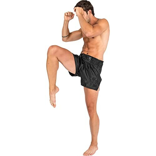 Man in kickboxing pose wearing black shorts