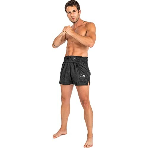 Man in black boxing shorts posing