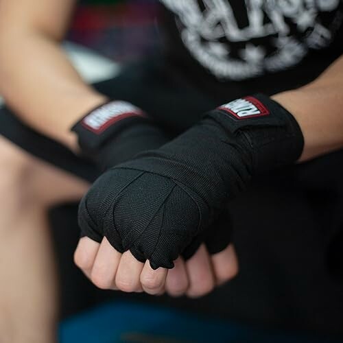 Person with black hand wraps ready for boxing.